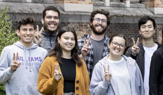 The Velian group in front of Bagley Hall giving the peace sign