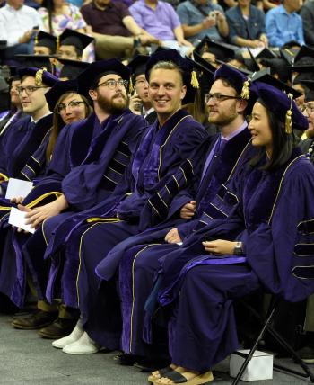 PhD graduates dressed in UW regalia sit in a row at the commencement celebration for the Departments of Chemistry and Biochemistry.