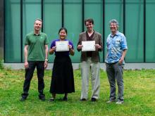 Two students pose with certificates, accompanied by CEI leadership