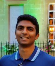 Headshot of Atch Gopalan with short dark brown hair, wearing a blue polo shirt.