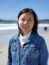 Demi Liu wearing a denim jacket at the beach