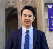 Justin Ho wearing a suit and tie in front of a Gothic style arch