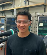 Sebastian Krajewski wearing safety goggles in a laboratory near a glove box
