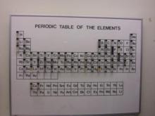 a periodic table with vial samples of elements