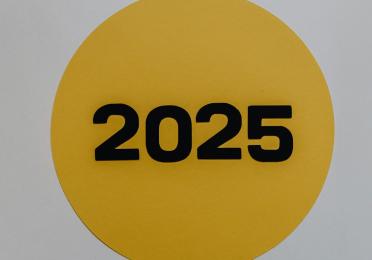 2025 paper cut out on a gold circle