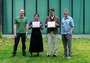 Two students pose with certificates, accompanied by CEI leadership