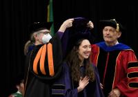 A graduate partakes in the PhD hooding ceremony.