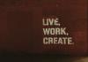 Words stenciled on a brick wall: Live. Work. Create.