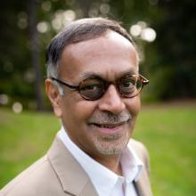 Pradip Rathod wears round glasses and a goatee